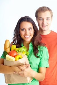 Happy couple of healthy eating followers looking at camera